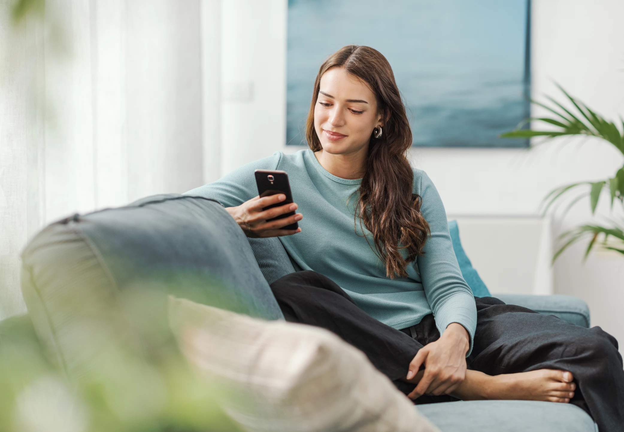 Person texting on couch with phone